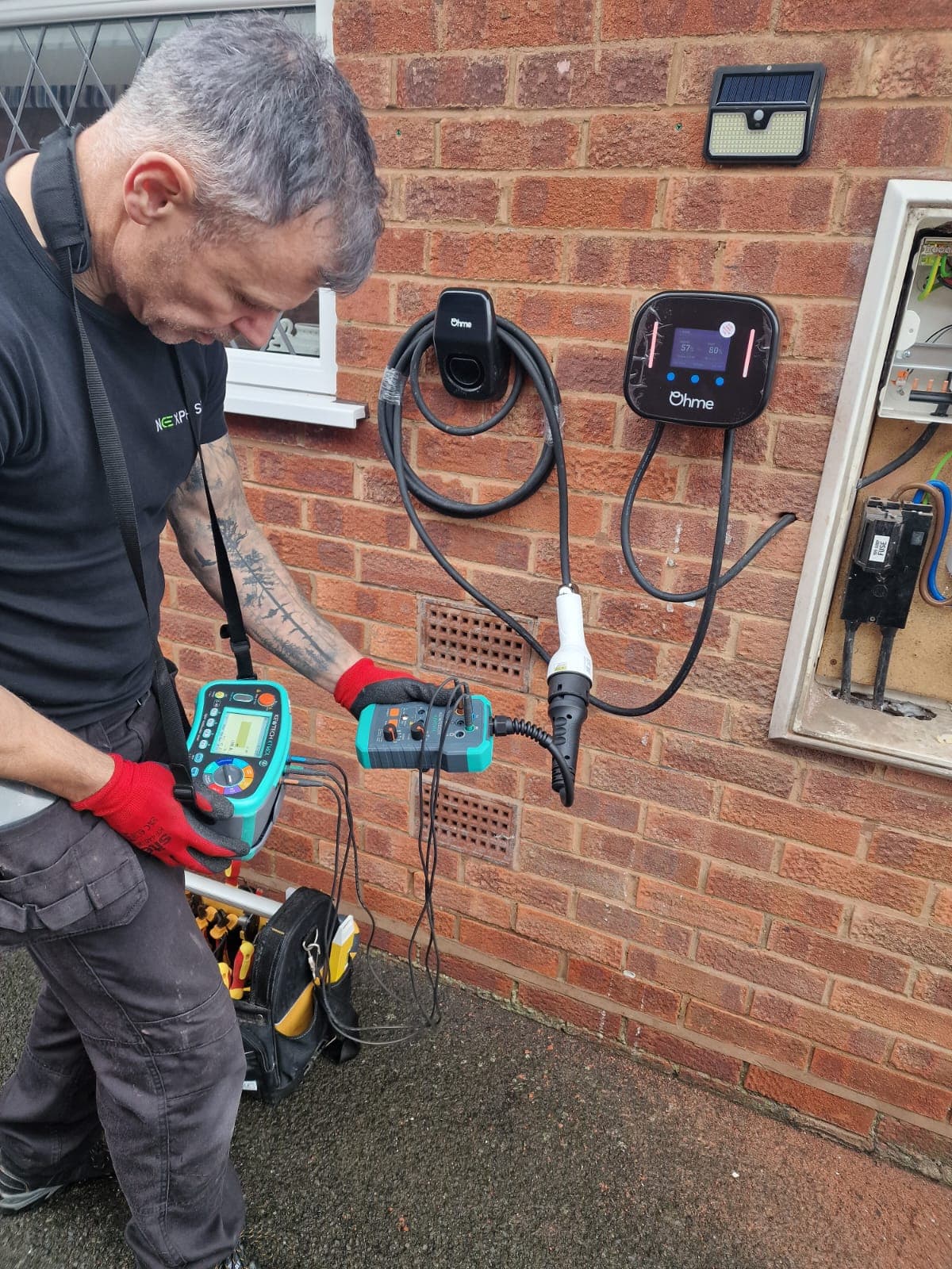Nexphase electrician testing an Ohme EV charger with a multifunction tester